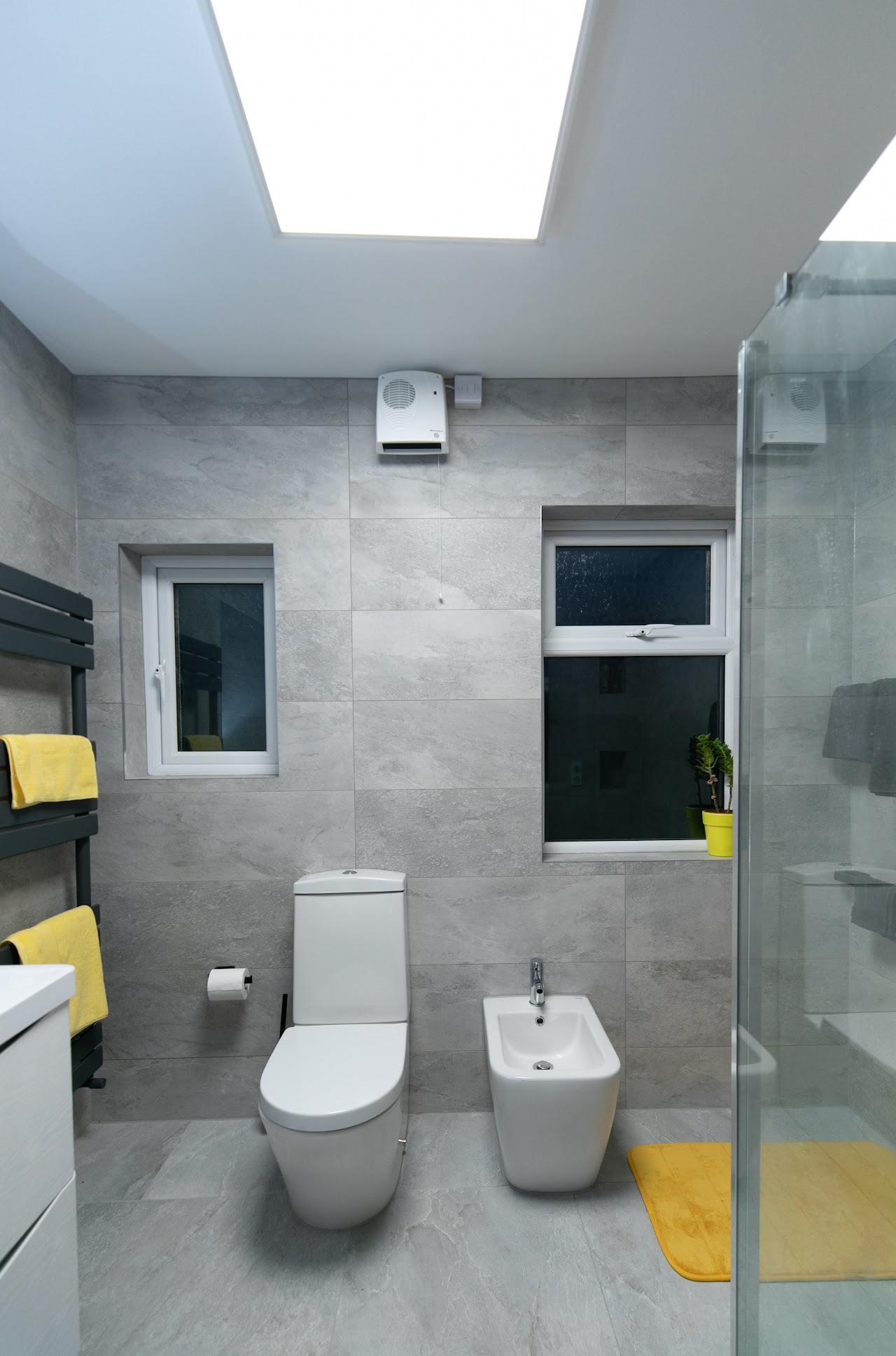Bathroom Fitting & Refurbishment in Wanstead, E11 — Skylit family bathroom with large-format porcelain tiling and walk-in shower enclosure — bathroom fitting by RJS Innovative Building, East London