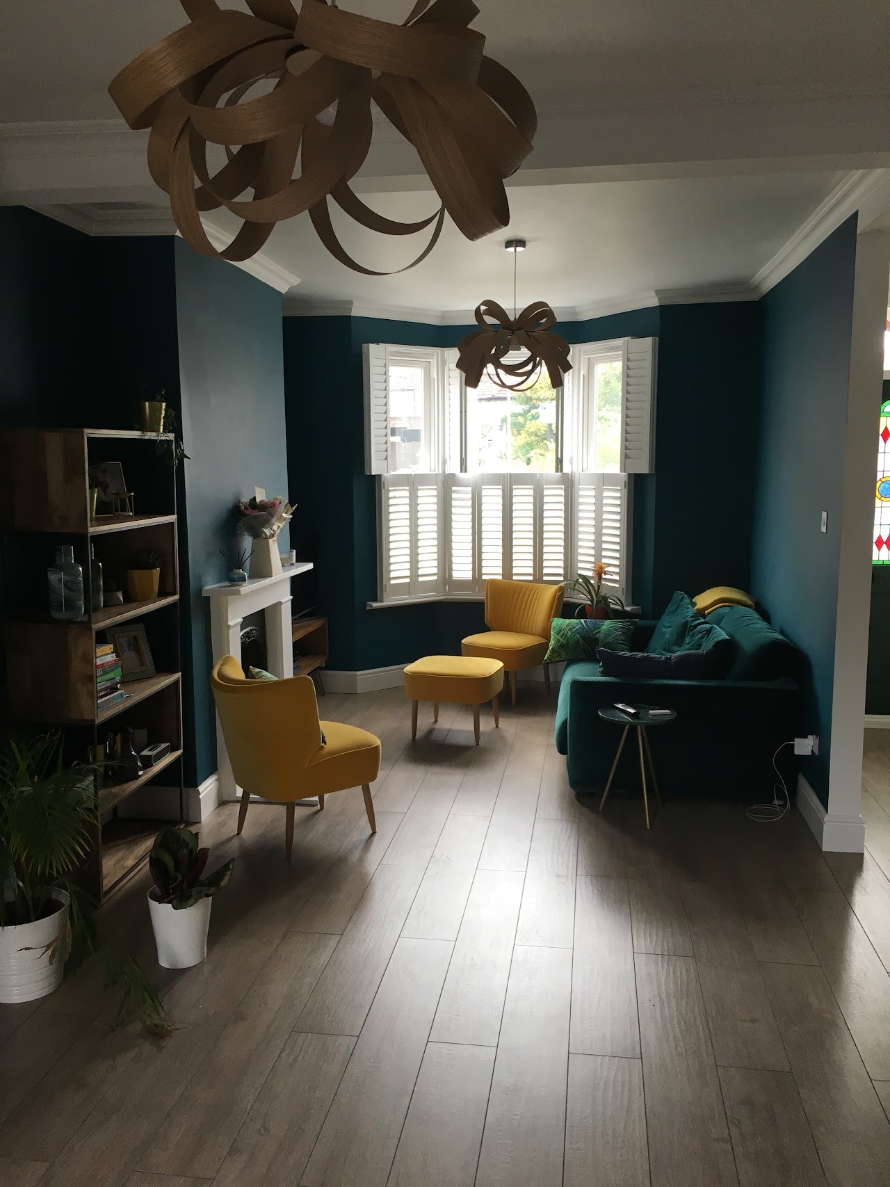 Refurbished living area with new flooring, teal walls and feature pendant — full house renovation by RJS Innovative Building, East London