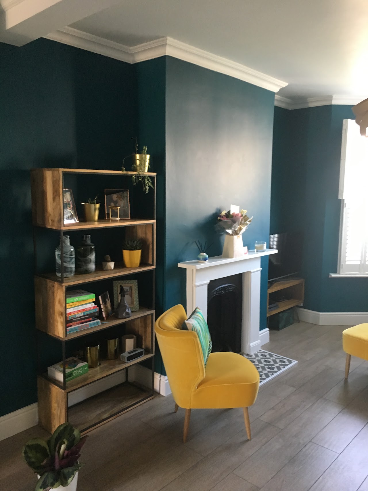 Completed side-return kitchen extension on a Leytonstone Victorian terrace with bifold doors and rooflight — Refurbished reception room with bookshelf, fireplace and accent armchair — full house renovation by RJS Innovative Building, East London