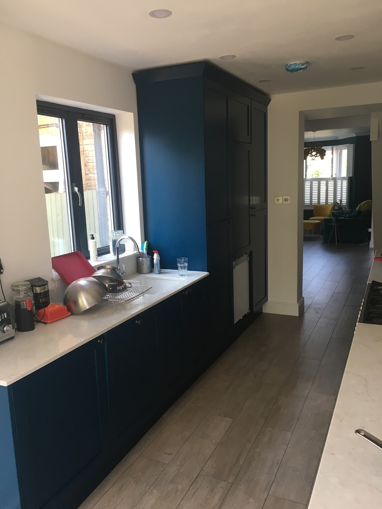 Bespoke navy shaker kitchen with quartz worktops and integrated appliances — kitchen fitting by RJS Innovative Building, East London