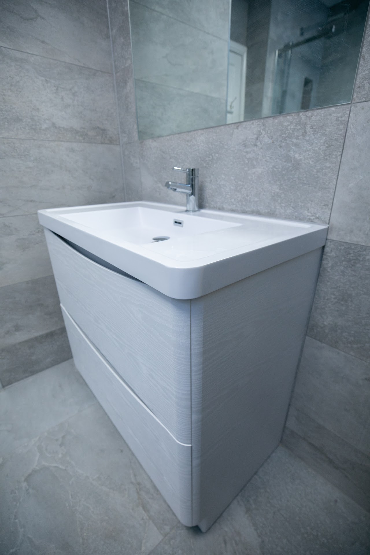 Bathroom Fitting & Refurbishment in Walthamstow, E17 — Wall-hung bathroom vanity with rectangular basin and chrome mixer on porcelain tiling — bathroom fitting by RJS Innovative Building, East London