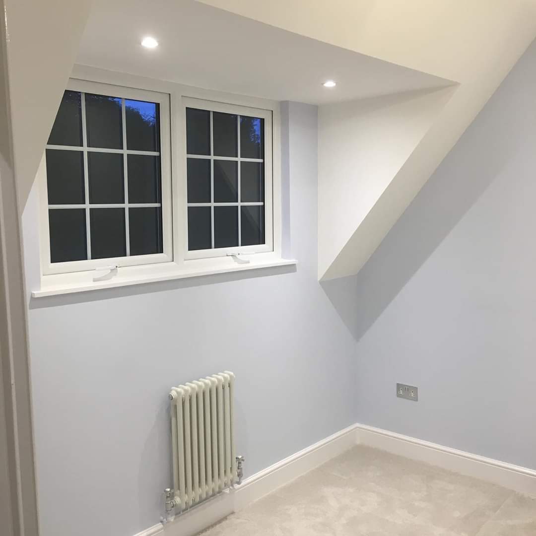 Completed kitchen refurbishment with shaker units and quartz worktops in a Romford semi — Newly decorated bedroom with column radiator and fresh paintwork — full house renovation by RJS Innovative Building, East London